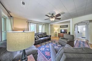 un soggiorno con divani e ventilatore a soffitto di Pet-Friendly Waterfront Hayesville Cottage! a Hayesville