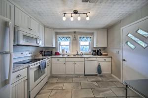 una cucina con armadietti bianchi ed elettrodomestici bianchi di Pet-Friendly Waterfront Hayesville Cottage! a Hayesville