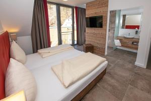 a bedroom with a large bed and a bathroom at Landhotel Weihermühle in Thaleischweiler-Fröschen +48 photos