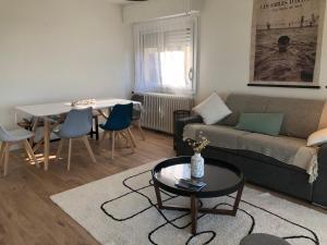 un salon avec un canapé et une table dans l'établissement Appartement Le Marbella, à Les Sables-dʼOlonne