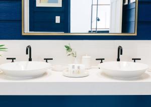 ein Badezimmer mit zwei Waschbecken und zwei Spiegeln in der Unterkunft Pink Sands Resort in Harbour Island