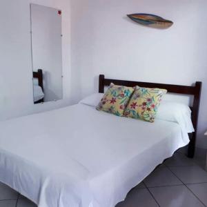 1 dormitorio con 2 camas, sábanas blancas y almohada en Pousada do Cacau, en Arraial d'Ajuda