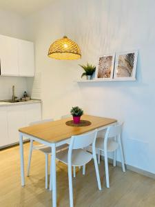 y cocina con mesa de comedor y sillas. en Modern City Apartment en Módena