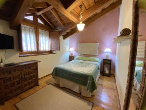 1 dormitorio con 1 cama, vestidor y TV en pension trescasas, en Trescasas