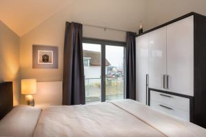 ハイリゲンハーフェンにあるOstsee - Appartement Nr 63 "Möwennest" im Strand Resortのベッドルーム1室(ベッド1台、大きな窓付)