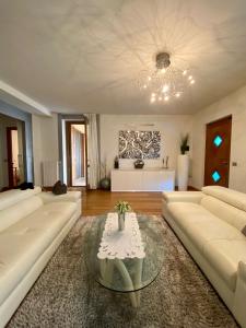 a living room with a white couch and a table at Franciacorta Suite in Corte Franca