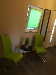 two green chairs and a table in a room at LandLoft in Tauberbischofsheim