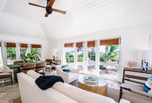 sala de estar con muebles blancos y ventilador de techo en Pink Sands Resort, en Harbour Island