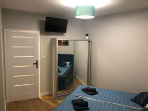Habitación pequeña con 2 camas y espejo. en Klimatyzowany Apartament EGIPT z sauną i miejscem parkingowym, en Kielce