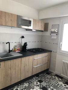une cuisine avec un évier et une cuisinière four supérieur dans l'établissement Appartement Le Marbella, à Les Sables-dʼOlonne 8 autres photos