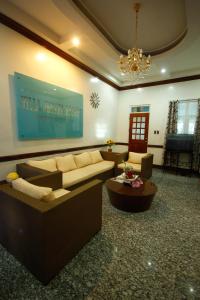 a living room with couches and a chandelier at Villa Jhoana Resort in Angono