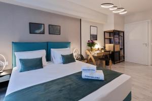 1 dormitorio con 1 cama grande y cabecero azul en Trendy Hotel by Athens Prime Hotels en Atenas