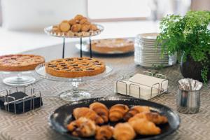 a table topped with plates of pastries and pies at Hotel Crystal in Preganziol