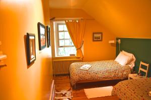 a small room with two beds and a window at Le Passe-Partout in Cowansville