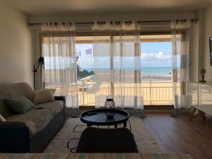 - un salon avec un canapé et une vue sur la plage dans l'établissement Appartement Le Marbella, à Les Sables-dʼOlonne