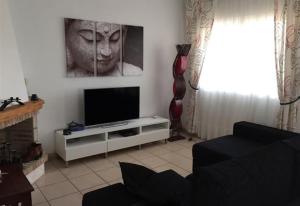 sala de estar con TV de pantalla plana en un soporte en Townhouse in Cabo roig Aguamarina, en Cabo Roig
