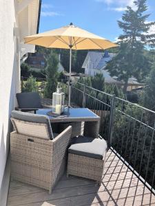 una mesa de patio y sillas con una sombrilla en el balcón en "GESTRANDET" in der Villa Katharina- en Dierhagen