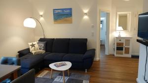 sala de estar con sofá azul y mesa en "GESTRANDET" in der Villa Katharina- en Dierhagen