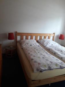 ハーフクルークにあるLandhaus-Marwede App 1のベッドルーム1室(木製ベッド1台、ランプ2つ付)
