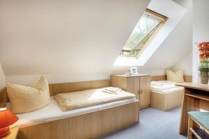 ツィングストにあるAm Deich 27のベッドと窓が備わる小さな客室です。