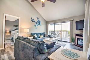 a living room with a couch and a tv at Waterfront Ozark Gem with Pool Access and Lake Views! in Lake Ozark