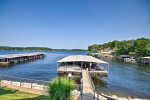 Waterfront Ozark Gem with Pool Access and Lake Views! في بحيرة أوزارك: مرسى على بحيرة مع قوارب في الماء