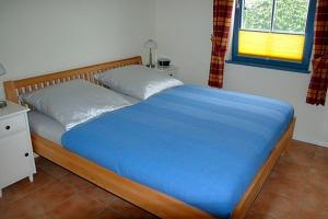 a bed in a bedroom with a blue blanket on it at Ut Kiek 4 in Zingst