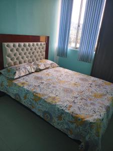 SANDY APARTAMENTO في سانتا روزا دي كابال: غرفة نوم بسرير ولحاف ورد ونافذة