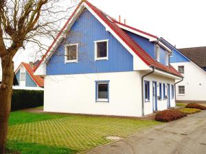 ein blau-weißes Haus mit rotem Dach in der Unterkunft Birkenstraße 6j in Zingst
