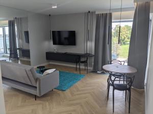 a living room with a couch and a tv and a table at Śledź Gdynia - YACHT PARK in Gdynia