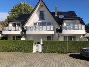 a white house with a white fence in front of it at Sunshine in Zingst