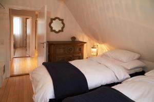 a bedroom with two white beds and a wooden floor at La Faya "Molerhüsli"- Gemütliches, gehobenes Ferienhaus in Muggenbrunn -Feldberg in Muggenbrunn