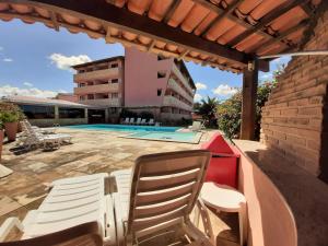 a patio with two chairs and a swimming pool at Atlântico Hotel Maceió in Maceió
