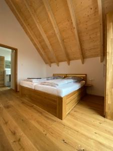 1 dormitorio con 1 cama en una habitación con suelo de madera en Ferienwohnung Apfelkrönchen, en Spiegelberg