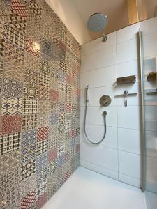y baño con ducha y mosaicos en la pared. en Ferienwohnung Apfelkrönchen, en Spiegelberg