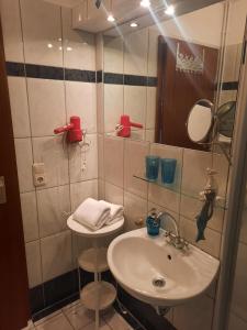 La salle de bains est pourvue d'un lavabo et d'un miroir. dans l'établissement Nielsen Apartment 1, à Hüsby