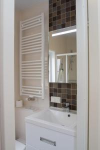 een witte badkamer met een wastafel en een spiegel bij Chalet bis 6 Personen ohne Hund - a16982 in Flüthörn