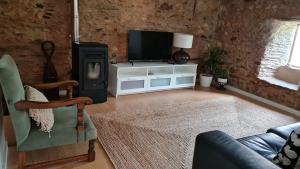 a living room with a tv and a couch at Casa da Ti Adélia in Janeiro de Cima