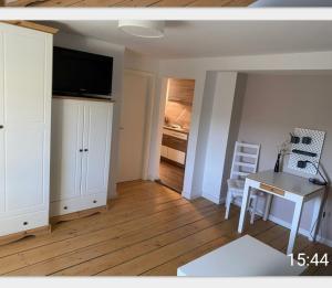 ein kleines Wohnzimmer mit einem Schreibtisch und einem TV in der Unterkunft Ferienwohnung im Zanderhaus in Sabel