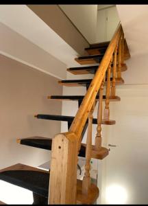 un escalier en bois avec des marches noires dans une maison dans l'établissement Ferienwohnung im Zanderhaus, à Sabel