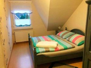ヴェルドゥムにあるFerienwohnung STEUERMANN in Werdumの窓付きの客室の小さなベッド1台分です。