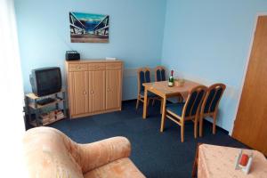 Zimmer mit einem Tisch und Stühlen sowie einem TV in der Unterkunft Haus Delfin Fewo 4 in Dahme