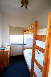 a bedroom with two bunk beds and a desk at Haus Delfin Fewo 4 in Dahme