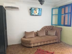 Hôtel Agnaou في مراكش: أريكة بنية موجودة في غرفة المعيشة