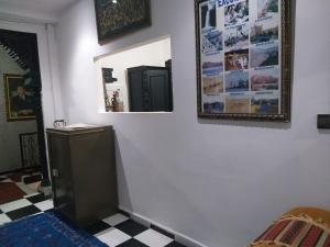 Habitación con pared blanca y espejo. en Hôtel Agnaou en Marrakech