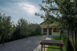 a house with a fence and a bench in the yard at House of Forest in Zărneşti