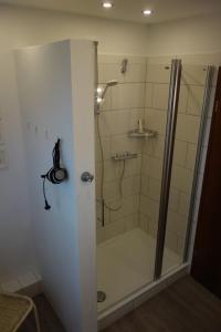 a shower with a glass door in a bathroom at Haus Mehler in Heiligenhafen