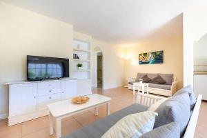 ein Wohnzimmer mit einem Sofa und einem TV in der Unterkunft Carihuela Front Beach in Torremolinos