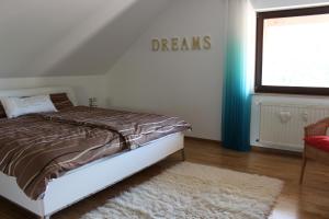 um quarto com uma cama e uma placa que lê sonhos em Ferienwohnung Krick em Bad Soden-Salmünster