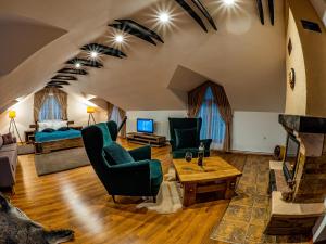 ein Wohnzimmer mit Kamin und einer Couch und Stühlen in der Unterkunft Casa Delia in Câmpulung Moldovenesc + 15 Fotos